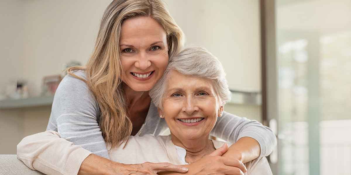 older and younger women smiling